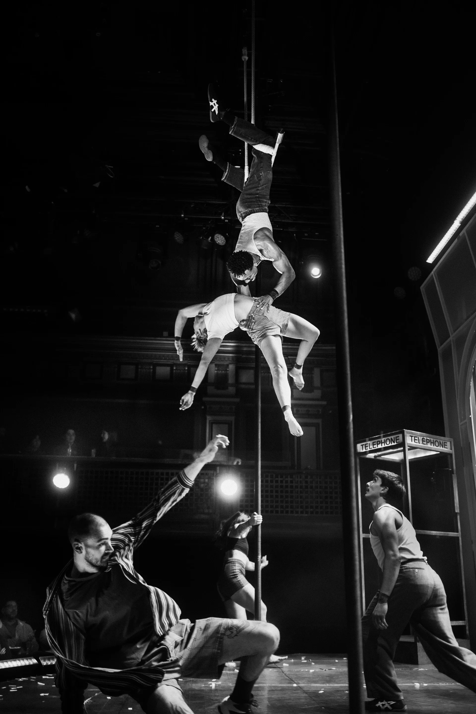 Several acrobats form a vertical stacked balance onstage.